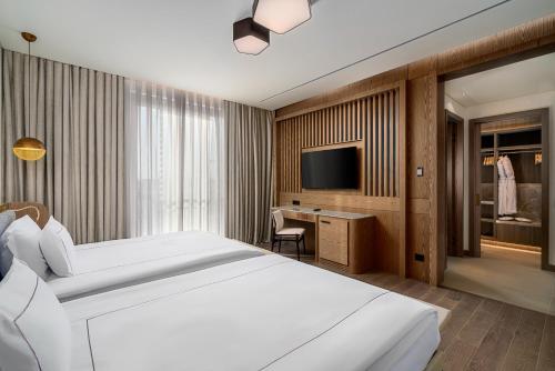 a bedroom with a large white bed and a television at Bayou Villas Antalya - Ultra All Inclusive in Antalya