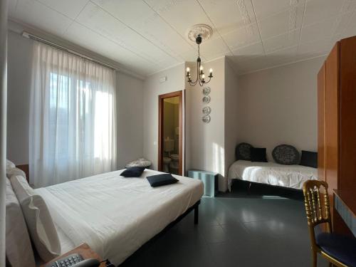 1 dormitorio con cama y lámpara de araña en Hotel La Bussola, en Cittiglio