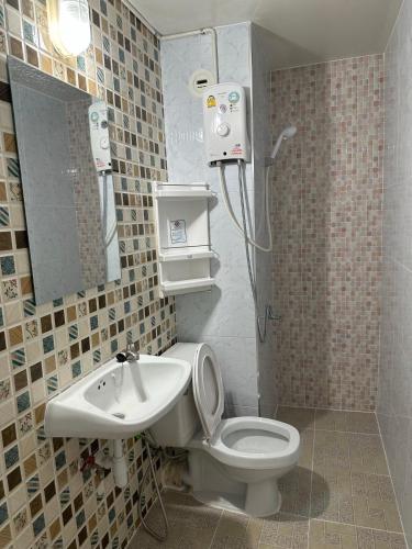 a bathroom with a shower and a toilet and a sink at Muangthongthani Rental/Khun Dan in Nonthaburi