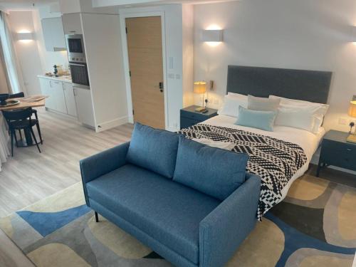 ロンドンにあるChamber St Apartmentsのベッドルーム1室(ベッド1台、青い椅子付)