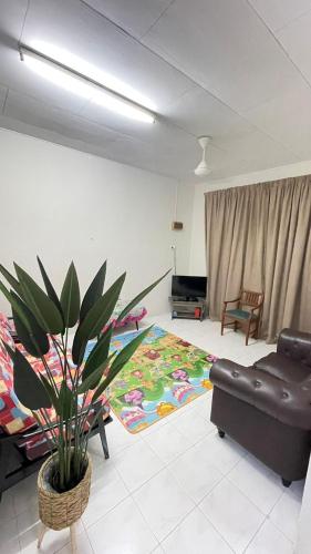 a living room with a couch and a plant at Homestay Port Dickson in Port Dickson