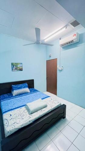 a bedroom with a bed in a blue room at Homestay Port Dickson in Port Dickson