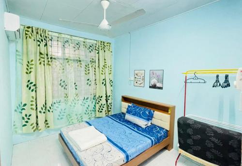 a blue bedroom with a bed and a window at Homestay Port Dickson in Port Dickson