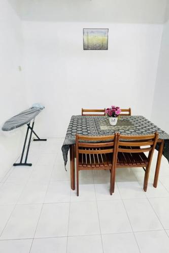 a table and bench with a table and flowers on it at Homestay Port Dickson in Port Dickson