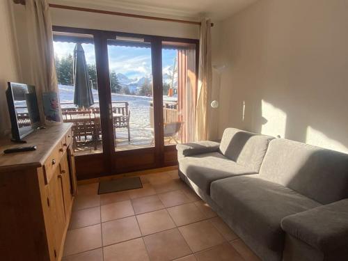 a living room with a couch and a view of the ocean at Joue du Loup, appartement F3, pied des pistes in Le Dévoluy