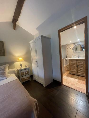 a bedroom with a bed and a bathroom with a mirror at Moulin de Laboirie in Bazas
