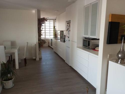 a kitchen with white cabinets and a wooden floor at Luxury renovated apartment with terrace in Madrid in Madrid