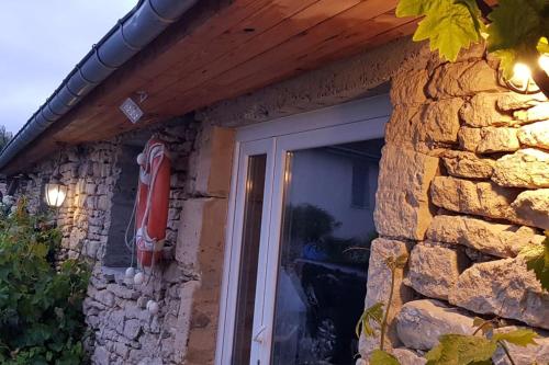 a stone house with a door and a stone wall at L'Ancre du Bessin - Proximité Bayeux et plages du débarquement - D-DAY - Spa en option - Accessible PMR in Saint-Vigor-le-Grand