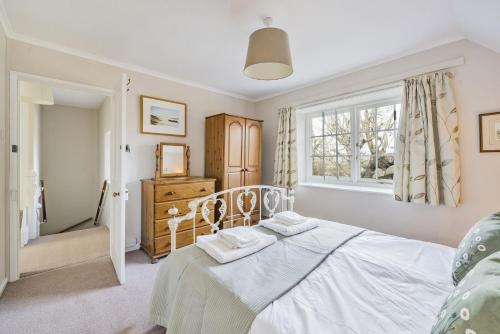1 dormitorio con cama y ventana en East Cottage, en Weymouth