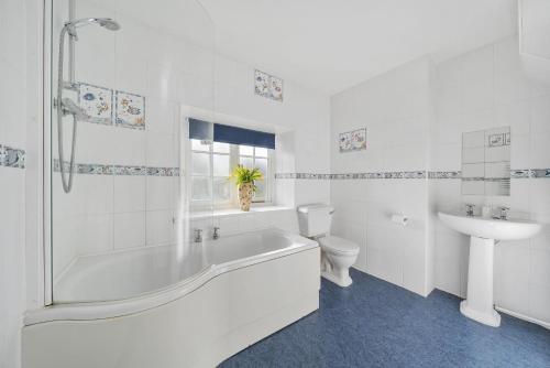ein Badezimmer mit Badewanne, Toilette und Waschbecken in der Unterkunft East Cottage in Weymouth