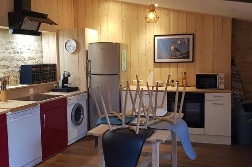 a kitchen with a refrigerator and a table with chairs at L'Ancre du Bessin - Proximité Bayeux et plages du débarquement - D-DAY - Spa en option - Accessible PMR in Saint-Vigor-le-Grand
