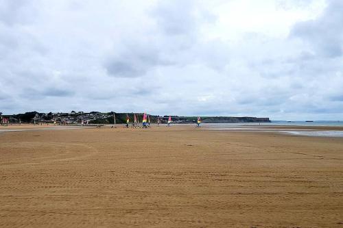 a beach with people walking on the sand at L'Ancre du Bessin - Proximité Bayeux et plages du débarquement - D-DAY - Spa en option - Accessible PMR in Saint-Vigor-le-Grand