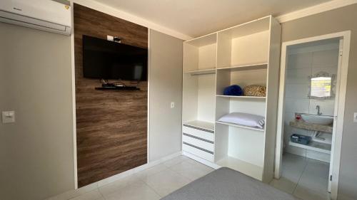 ボンビーニャスにあるResidencial Rumo ao Mar - Bombinhas-SCの部屋には洗面台とテレビ付きのバスルームがある