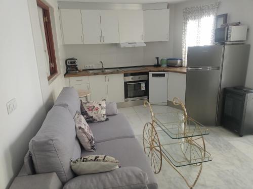 uma sala de estar com um sofá e uma cozinha em Piso junto al mar de 80m² em Villajoyosa