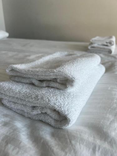 a white towel sitting on top of a bed at Simple studio for two in Turku Center in Turku