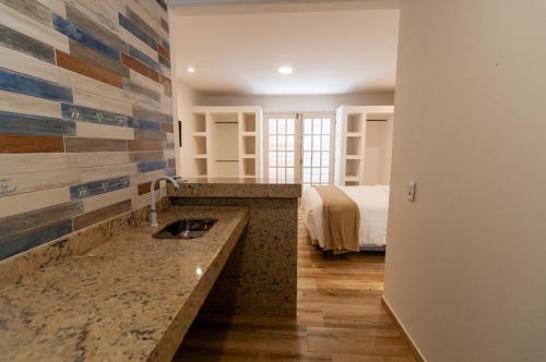 a bathroom with a sink and a bed in a room at Pousada Mar de Geribá in Búzios