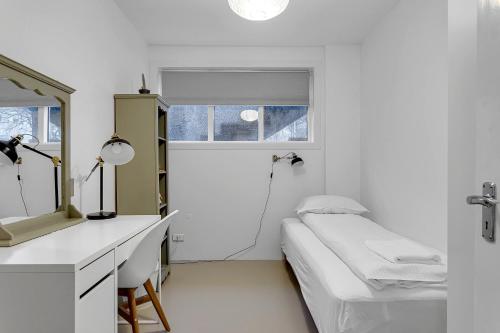 a white room with a bed and a mirror at Spacious and Central Apartment - 3 Bedrooms in Reykjavík