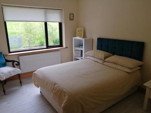 - une chambre avec un grand lit et une fenêtre dans l'établissement Greatlawne, à Killarney