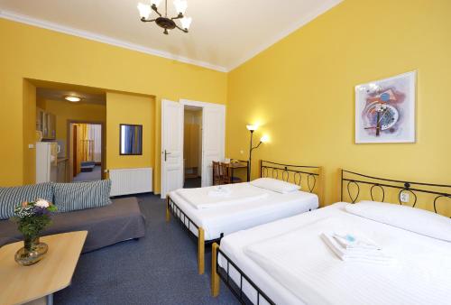 Habitación de hotel con 2 camas y sofá en Hotel Boston en Karlovy Vary