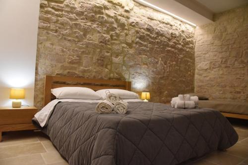 a bedroom with a large bed and a stone wall at Altemura Suites in Bari