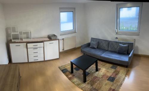 uma sala de estar com um sofá e uma mesa em Gästehaus - Klingengasse 2, Rainau em Rainau