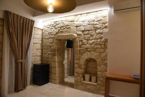 Una chimenea de piedra en una habitación con cortina en Altemura Suites, en Bari