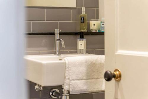 um lavatório branco na casa de banho com uma toalha em Luxury St Andrews Apartment - 5 mins to Old Course em St. Andrews