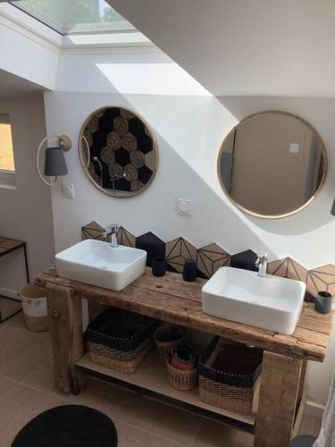 une salle de bain avec deux lavabos et deux miroirs dans l'établissement La maison d’Eugenia, à Paimpol