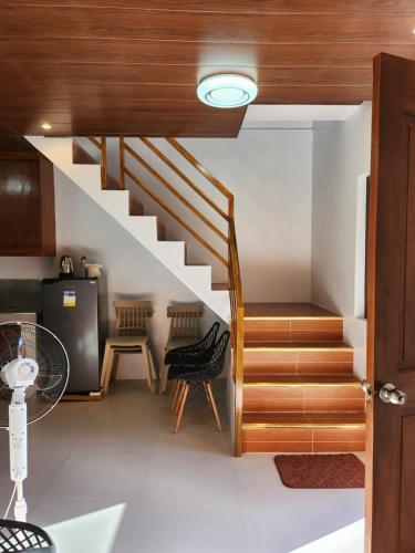 a staircase in a house with two chairs at BALAI MALINAWON - Balai 3 in General Luna