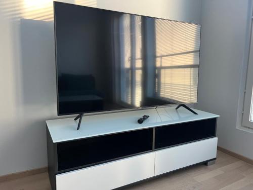 een flatscreen-tv op de top van een witte dressoir bij Simple studio for two in Turku Center in Turku