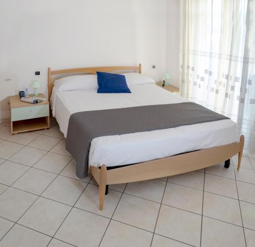een slaapkamer met een groot bed met een blauw kussen bij Residenza Raggio in Riccione