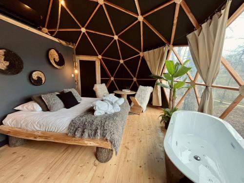 a room with a bed and a bath tub at Whaka Lodge in Seissan