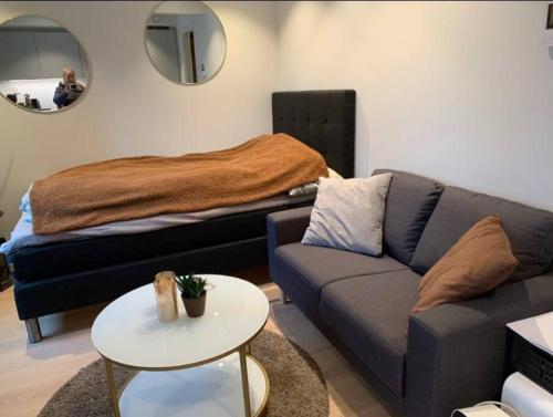 un soggiorno con divano e letto di Hotell-leilighet i sentrum a Bodø