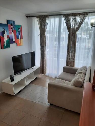 uma sala de estar com um sofá e uma televisão de ecrã plano em Departamento 3D con 1 Estacionamiento em Puerto Montt