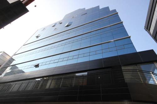 un edificio de cristal alto con un cielo azul en el fondo en Busan Platinum Hotel Nampo, en Busan
