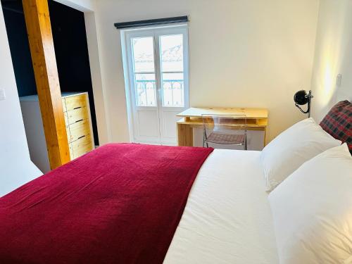 Schlafzimmer mit einem Bett mit einer roten und weißen Decke in der Unterkunft Castle cozy apartment in Lissabon