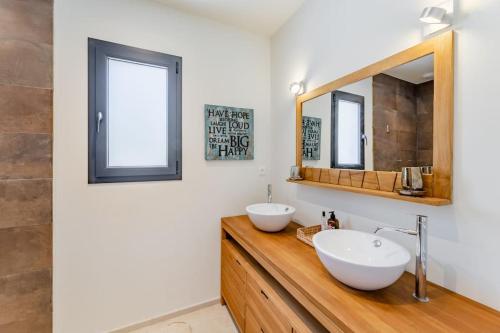 une salle de bain avec deux lavabos et un miroir dans l'établissement VillaCadière Vue Mer et Vignes Piscine à débordement, à Laouque