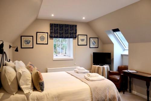 a bedroom with a bed and a desk and a window at Tigh an Truish Inn in Oban