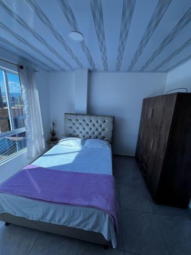 1 dormitorio con 1 cama, vestidor y ventana en Apto Escalini Mansión Pitalito, en Pitalito