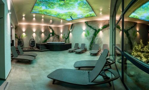 a waiting room with chairs and a tub and trees at Malina Apartamenty in Szklarska Poręba