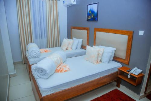 two twin beds in a room with a phone at LE GRAND MARIE HOTEL in Dar es Salaam
