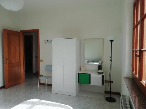 ein Wohnzimmer mit einem weißen Schrank und einem Stuhl in der Unterkunft Su domus de Corinne in Tratalias