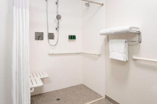 a white bathroom with a shower and a toilet at Courtyard St. Petersburg Clearwater in Clearwater