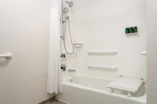 y baño blanco con ducha y aseo. en Courtyard St. Petersburg Clearwater en Clearwater