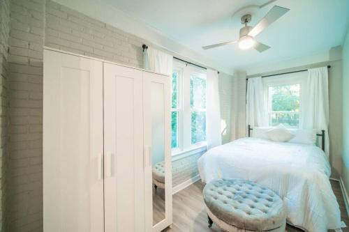 a white bedroom with a bed and a ceiling fan at Bungalow in the Heart of Heathwood in Columbia