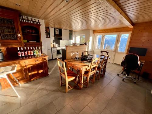 a kitchen with a wooden table and chairs at Chalet La Louise avec vue imprenable in Crans-Montana