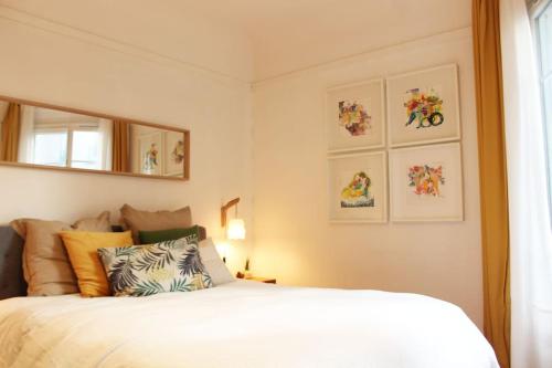 une chambre avec un lit blanc et un miroir dans l'établissement Paris Langeac Apartments, à Paris