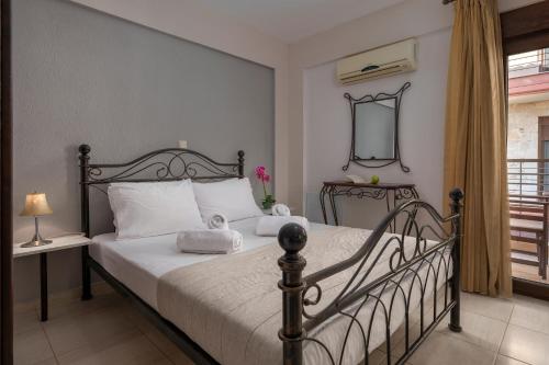 a bedroom with a bed with white sheets and a mirror at Eleon Suites & Apartments in Afitos
