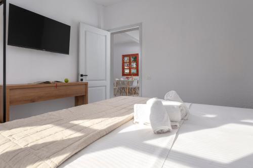 a bedroom with a bed with a tv on the wall at Eleon Suites & Apartments in Afitos
