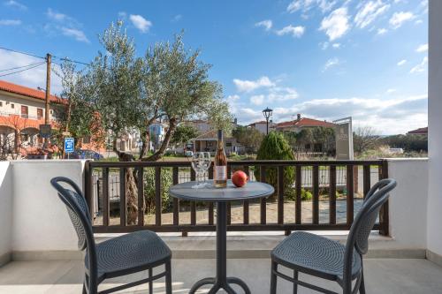 a table with two chairs and an apple on a balcony at Eleon Suites & Apartments in Afitos